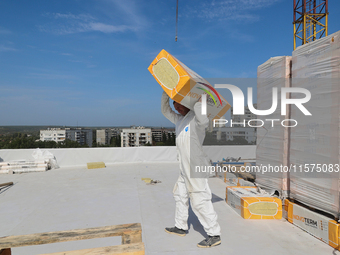 A construction worker restores a multi-storey residential building damaged by Russian shelling in Kharkiv, Ukraine, on September 12, 2024. N...