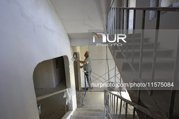 A construction worker restores a multi-storey residential building damaged by Russian shelling in Kharkiv, Ukraine, on September 12, 2024. N...