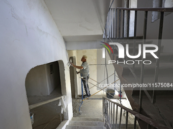 A construction worker restores a multi-storey residential building damaged by Russian shelling in Kharkiv, Ukraine, on September 12, 2024. N...