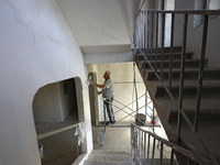 A construction worker restores a multi-storey residential building damaged by Russian shelling in Kharkiv, Ukraine, on September 12, 2024. N...