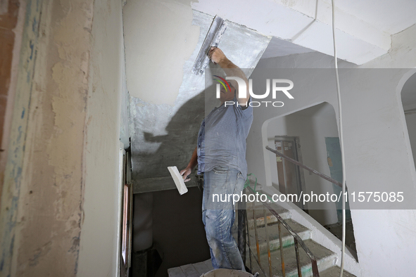 A construction worker restores a multi-storey residential building damaged by Russian shelling in Kharkiv, Ukraine, on September 12, 2024. N...