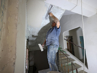 A construction worker restores a multi-storey residential building damaged by Russian shelling in Kharkiv, Ukraine, on September 12, 2024. N...