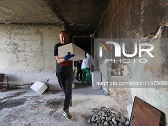 Construction workers restore a multi-storey residential building damaged by Russian shelling in Kharkiv, Ukraine, on September 12, 2024. NO...