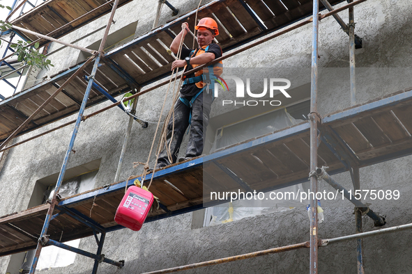 A construction worker restores a multi-storey residential building damaged by Russian shelling in Kharkiv, Ukraine, on September 12, 2024. N...