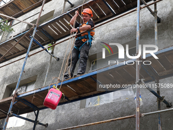 A construction worker restores a multi-storey residential building damaged by Russian shelling in Kharkiv, Ukraine, on September 12, 2024. N...