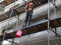 A construction worker restores a multi-storey residential building damaged by Russian shelling in Kharkiv, Ukraine, on September 12, 2024. N...