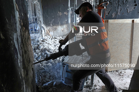 A construction worker restores a multi-storey residential building damaged by Russian shelling in Kharkiv, Ukraine, on September 12, 2024. N...