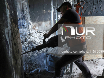 A construction worker restores a multi-storey residential building damaged by Russian shelling in Kharkiv, Ukraine, on September 12, 2024. N...