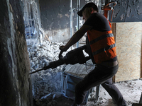 A construction worker restores a multi-storey residential building damaged by Russian shelling in Kharkiv, Ukraine, on September 12, 2024. N...