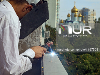 A construction worker restores a multi-storey residential building damaged by Russian shelling in Kharkiv, Ukraine, on September 12, 2024. N...