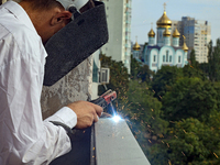 A construction worker restores a multi-storey residential building damaged by Russian shelling in Kharkiv, Ukraine, on September 12, 2024. N...