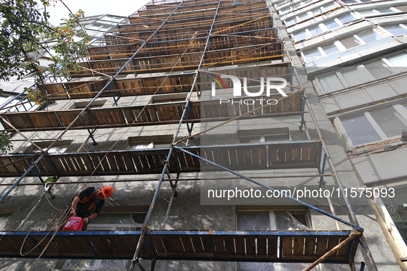 A construction worker restores a multi-storey residential building damaged by Russian shelling in Kharkiv, Ukraine, on September 12, 2024. N...