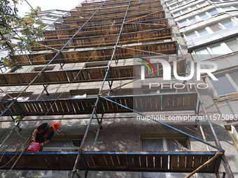 A construction worker restores a multi-storey residential building damaged by Russian shelling in Kharkiv, Ukraine, on September 12, 2024. N...