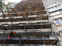 A construction worker restores a multi-storey residential building damaged by Russian shelling in Kharkiv, Ukraine, on September 12, 2024. N...