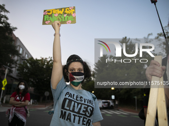 A person holds a sign with the text ''Jew for Palestine'' and poses for a photograph during a pro-Palestinian rally in front of the Israeli...