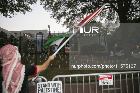 A person waves a Palestinian flag during a pro-Palestinian rally in front of the Israeli Embassy in Washington DC, USA, on September 14, 202...