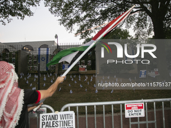 A person waves a Palestinian flag during a pro-Palestinian rally in front of the Israeli Embassy in Washington DC, USA, on September 14, 202...