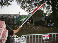 A person waves a Palestinian flag during a pro-Palestinian rally in front of the Israeli Embassy in Washington DC, USA, on September 14, 202...