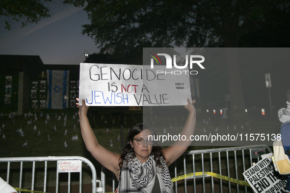 A person holds a sign with the text ''Genocide is not a Jewish Value'' during a pro-Palestinian rally in front of the Israeli Embassy in Was...