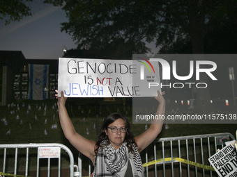 A person holds a sign with the text ''Genocide is not a Jewish Value'' during a pro-Palestinian rally in front of the Israeli Embassy in Was...