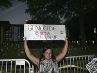 A person holds a sign with the text ''Genocide is not a Jewish Value'' during a pro-Palestinian rally in front of the Israeli Embassy in Was...