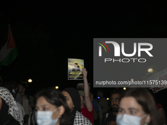 A person holds an image of Palestinian social media personality Medo Halimy during a pro-Palestinian rally in front of the Israeli Embassy i...