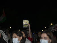 A person holds an image of Palestinian social media personality Medo Halimy during a pro-Palestinian rally in front of the Israeli Embassy i...