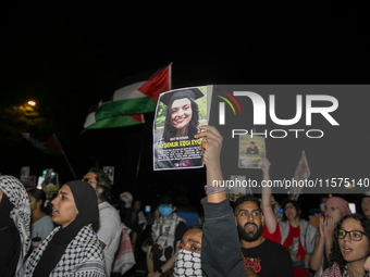 A person holds an image of Turkish-American human rights activist Aysenur Ezgi Eygi during a pro-Palestinian rally in front of the Israeli E...