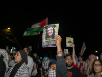 A person holds an image of Turkish-American human rights activist Aysenur Ezgi Eygi during a pro-Palestinian rally in front of the Israeli E...