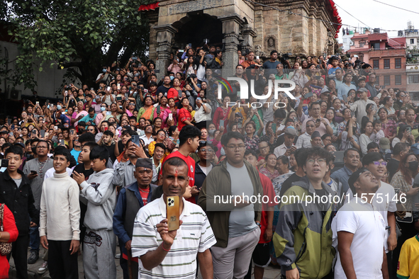 Revelers watch the sacred pole Ya:shi erection procession at Kathmandu Durbar Square in Kathmandu, Nepal, on September 15, 2024, ahead of th...