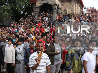 Revelers watch the sacred pole Ya:shi erection procession at Kathmandu Durbar Square in Kathmandu, Nepal, on September 15, 2024, ahead of th...