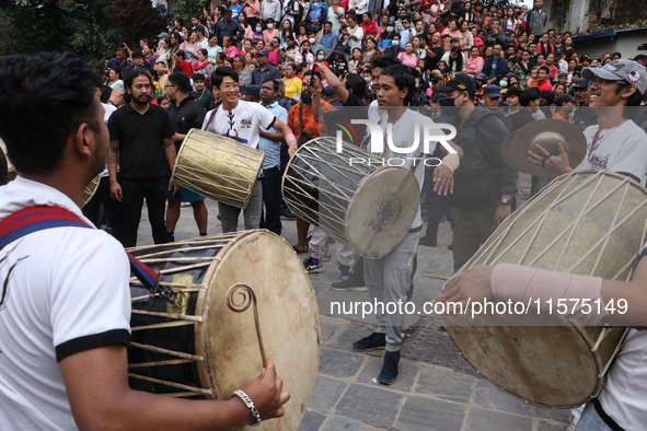 Nepali Hindu devotees play musical instruments as they erect a sacred pole locally called ''Ya:Shi,'' marking the formal start of Indra Jatr...