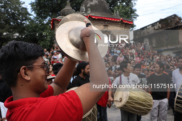 Nepali Hindu devotees play musical instruments as they erect a sacred pole locally called ''Ya:Shi,'' marking the formal start of Indra Jatr...