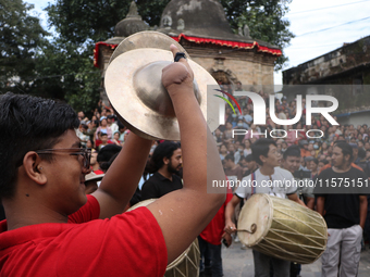 Nepali Hindu devotees play musical instruments as they erect a sacred pole locally called ''Ya:Shi,'' marking the formal start of Indra Jatr...