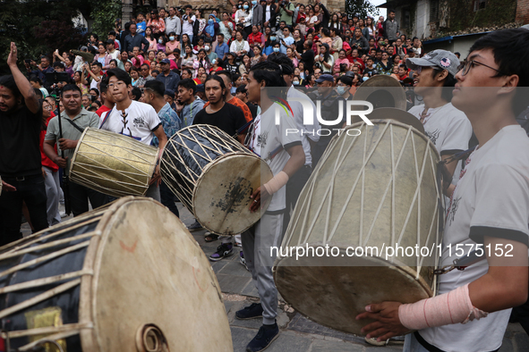 Nepali Hindu devotees play musical instruments as they erect a sacred pole locally called ''Ya:Shi,'' marking the formal start of Indra Jatr...