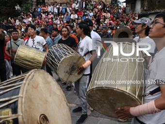 Nepali Hindu devotees play musical instruments as they erect a sacred pole locally called ''Ya:Shi,'' marking the formal start of Indra Jatr...