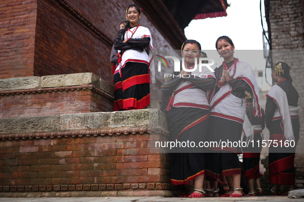 Nepali girls in Newari attire watch the sacred pole-Ya:shi erection procession at Kathmandu Durbar Square in Kathmandu, Nepal, on September...