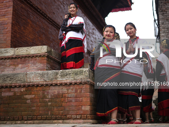 Nepali girls in Newari attire watch the sacred pole-Ya:shi erection procession at Kathmandu Durbar Square in Kathmandu, Nepal, on September...