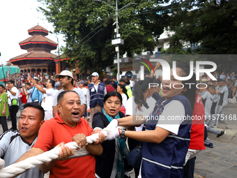 Nepali Hindu devotees pull a sacred pole locally called ''Ya: Shi,'' marking the formal start of Indra Jatra dedicated to the rain god Indra...