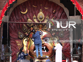 Nepali Hindu devotees clean the mask of the Nepali Hindu god Swet Bhairab ahead of the formal start of Indra Jatra dedicated to the rain god...