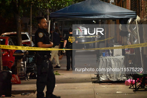 Police stand guard at the scene. Party balloons are visible at the crime scene. One man is dead and another man is injured but expected to s...