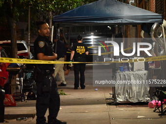 Police stand guard at the scene. Party balloons are visible at the crime scene. One man is dead and another man is injured but expected to s...