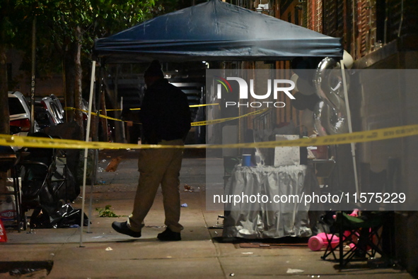 Police stand guard at the scene. Party balloons are visible at the crime scene. One man is dead and another man is injured but expected to s...