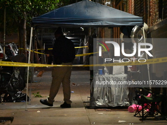 Police stand guard at the scene. Party balloons are visible at the crime scene. One man is dead and another man is injured but expected to s...