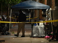 Police stand guard at the scene. Party balloons are visible at the crime scene. One man is dead and another man is injured but expected to s...