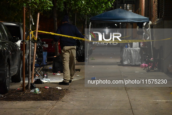 Police stand guard at the scene. Party balloons are visible at the crime scene. One man is dead and another man is injured but expected to s...