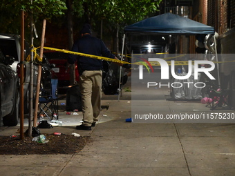 Police stand guard at the scene. Party balloons are visible at the crime scene. One man is dead and another man is injured but expected to s...