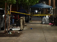 Police stand guard at the scene. Party balloons are visible at the crime scene. One man is dead and another man is injured but expected to s...