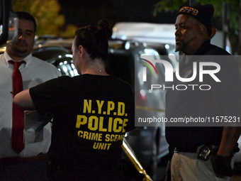 Investigators from the NYPD Crime Scene Unit investigate and place evidence markers and take photographs of the scene. One man is dead and a...