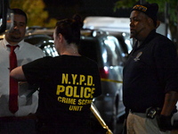 Investigators from the NYPD Crime Scene Unit investigate and place evidence markers and take photographs of the scene. One man is dead and a...